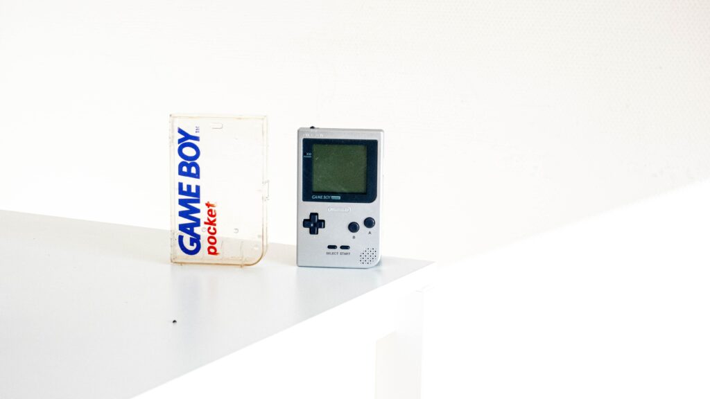 white Game boy standing on the surface infant of white wall