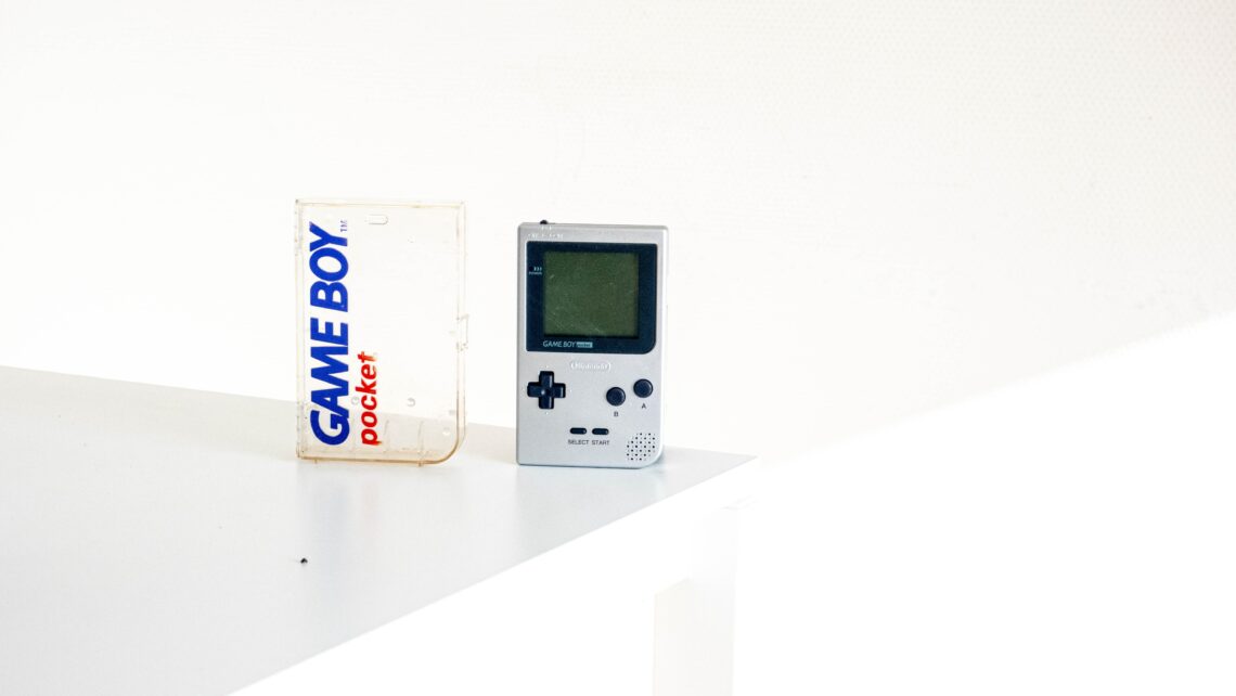 white Game boy standing on the surface infant of white wall