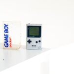 white Game boy standing on the surface infant of white wall