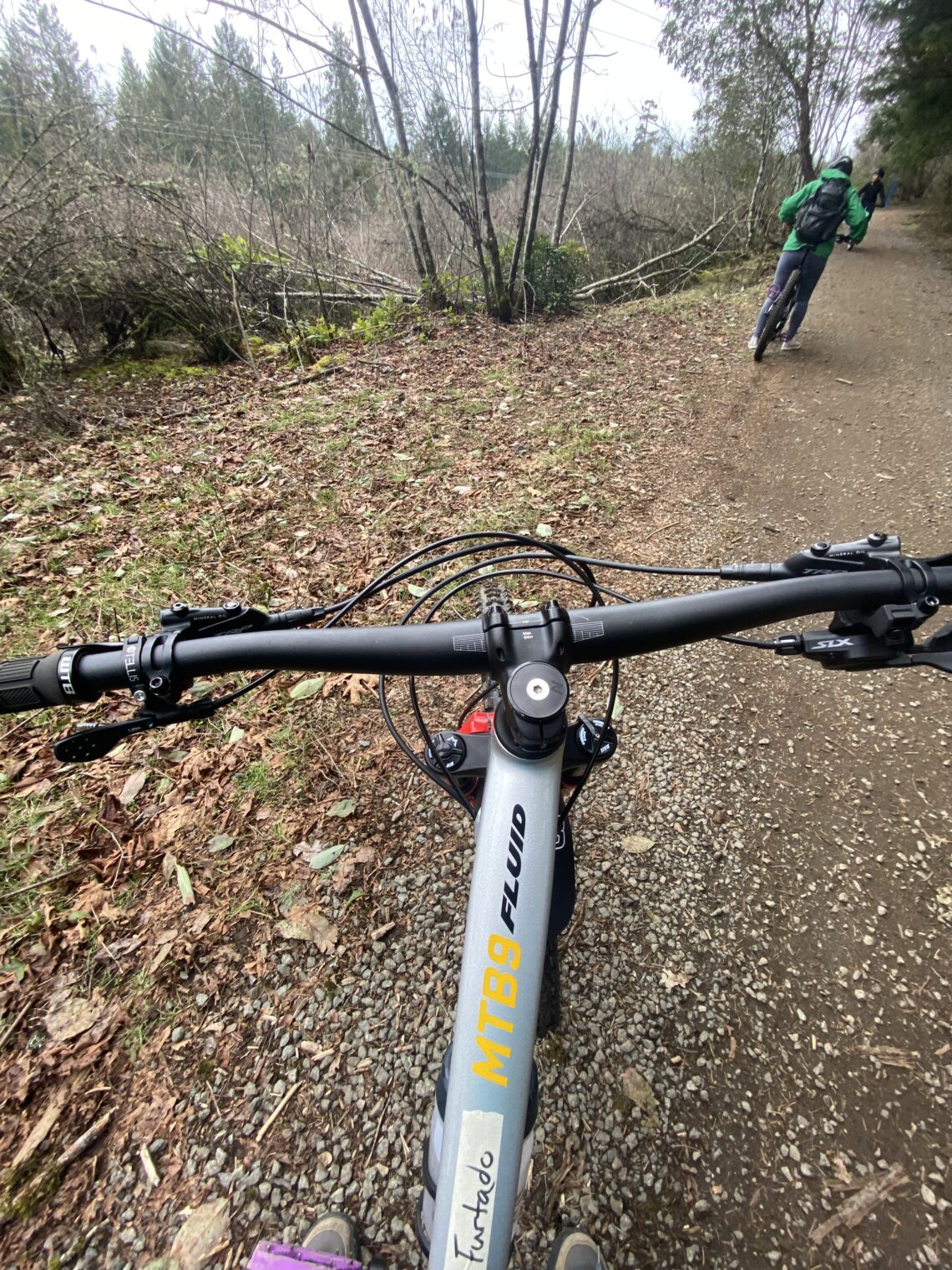 The handle bars of my mountain bike with a view of a gravel path